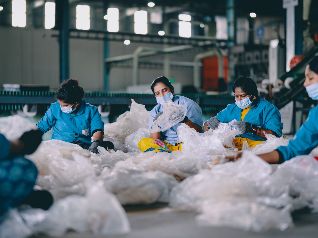 Eine Gruppe von Frauen sitzt auf dem Boden und sortiert Altplastik